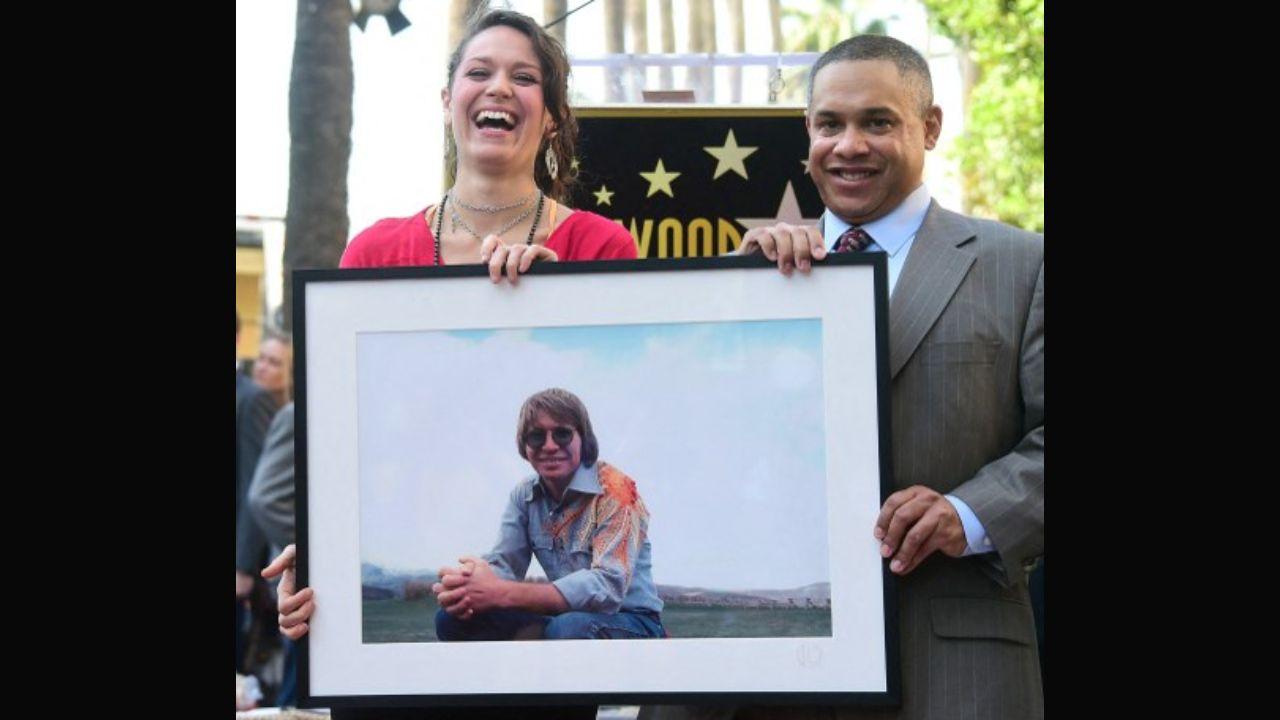 Henry John Deustchendorf Jr or John Denver, as he was more popularly known, was born on December 31, 1943 to Henry John Deustchendorf Sr and Erma Louise. Denver took to music at 11 after his grandmother gifted him a guitar, and went on to perform regularly in college. He adopted Denver as his surname because it was the capital of his favourite state, Colorado. He is said to have made the change because musician Randy Sparks told him his given name was too long to fit on announcement boards. The late John Denver's children Zak Deutschendorf (right) and Jesse Belle Denver (left) pose while holding a photo of their father following his posthumous Hollywood Star ceremony in 2014. Photo: AFP