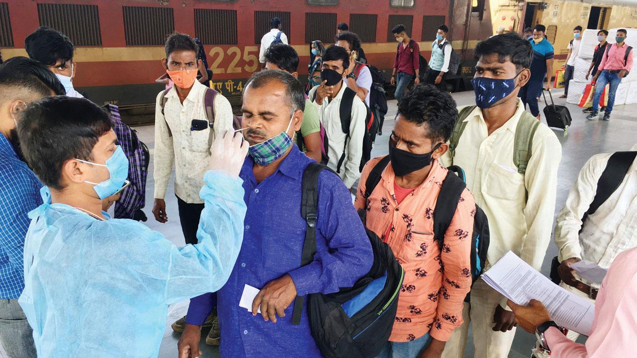 A health worker takes swab samples from passengers at LTT Kurla on Tuesday. Pic/Atul Kamble