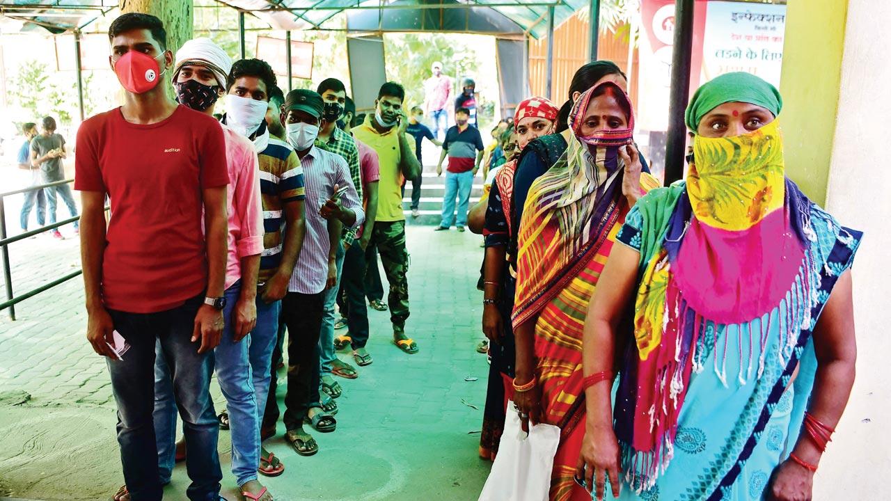 People wait for their turn to get inoculated at a hospital in Allahabad, UP, on Friday. Pic/AFP