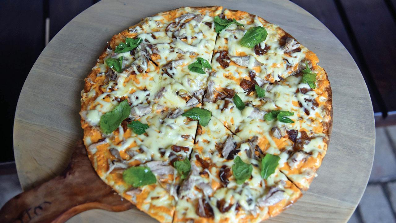 Confit of chicken, caramelised onion and arugula with paprika Parmesan pizza