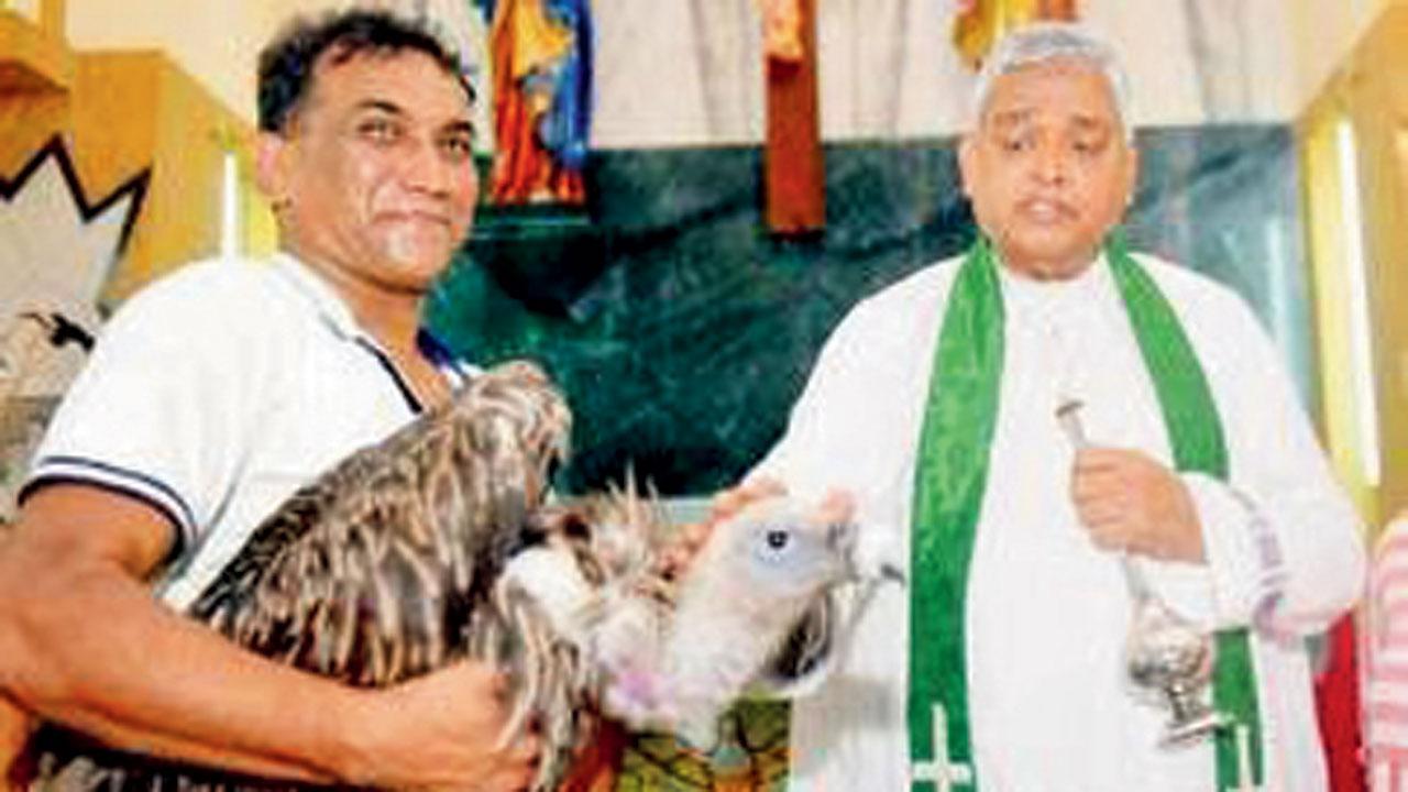 Fr. Joe D`Souza (right) blesses Booboo, a vulture, in 2018. Pic/Bipin Kokate