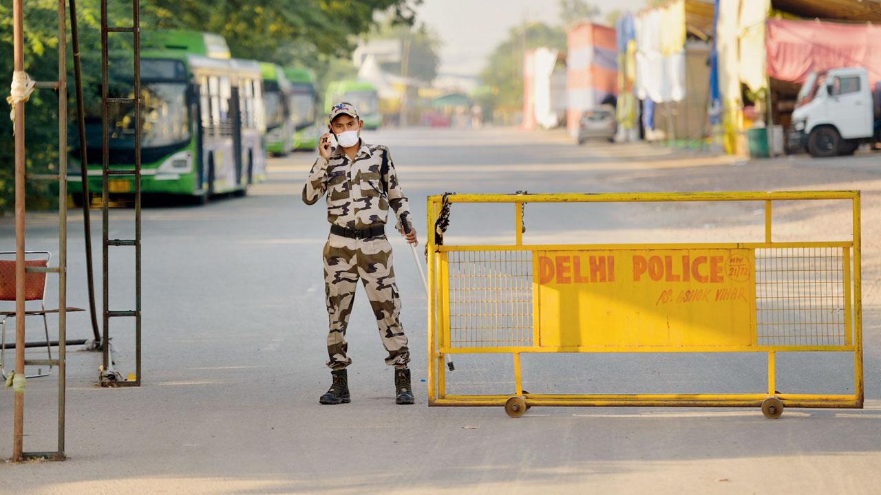 A security person keeps vigil at Singhu border near the site of farmers’ protest, in Delhi, on Friday. Pic/PTI