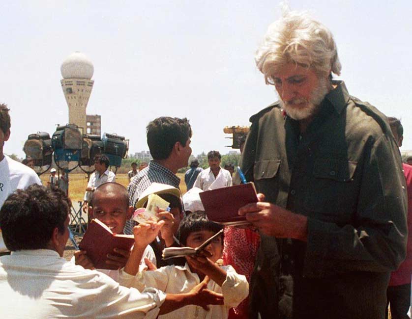 Amitabh Bachchan surrounded by autograph hunters on sets of one of his films.