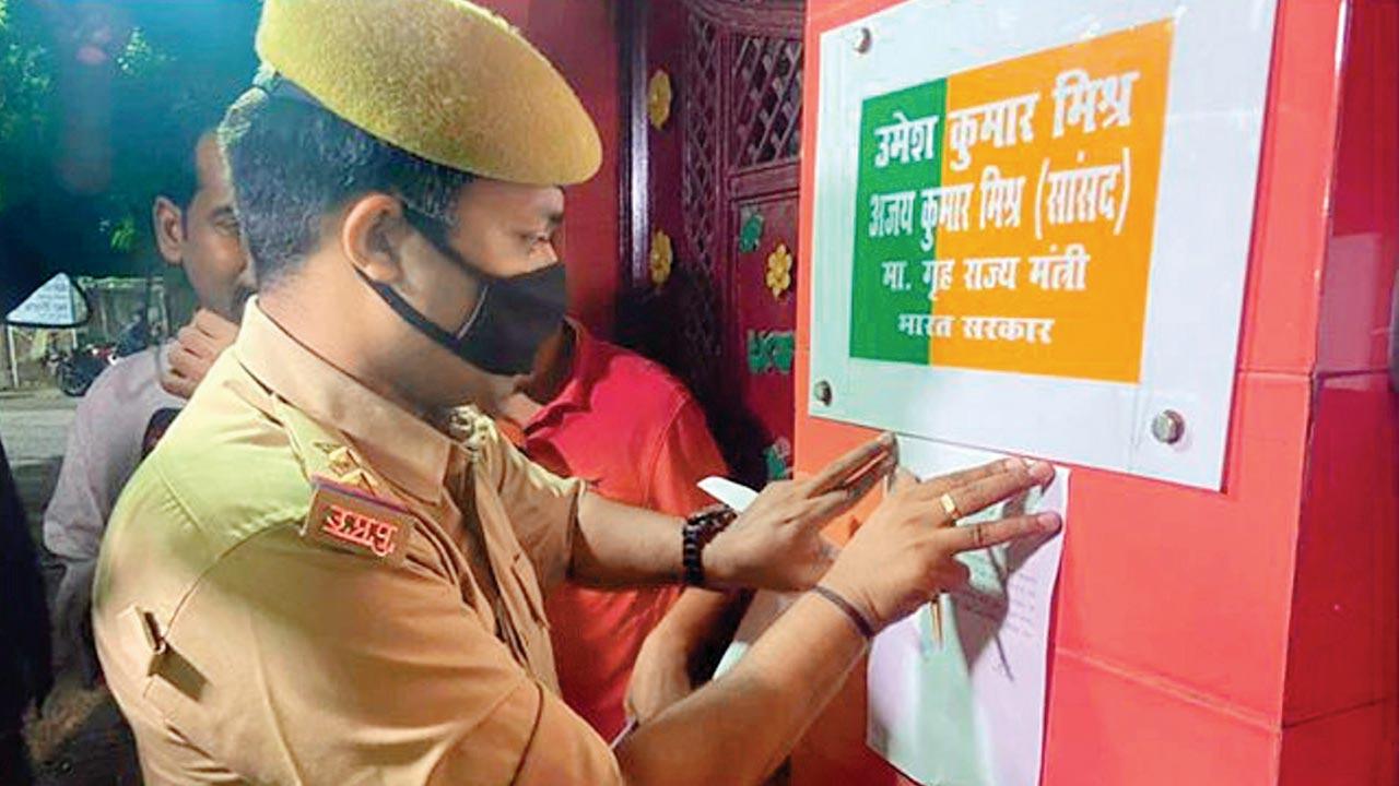 A cop pastes a summon notice outside Union minister Ajay Mishra’s house, for his son Ashish, at Lakhimpur Kheri, on Thursday. Pic/PTI