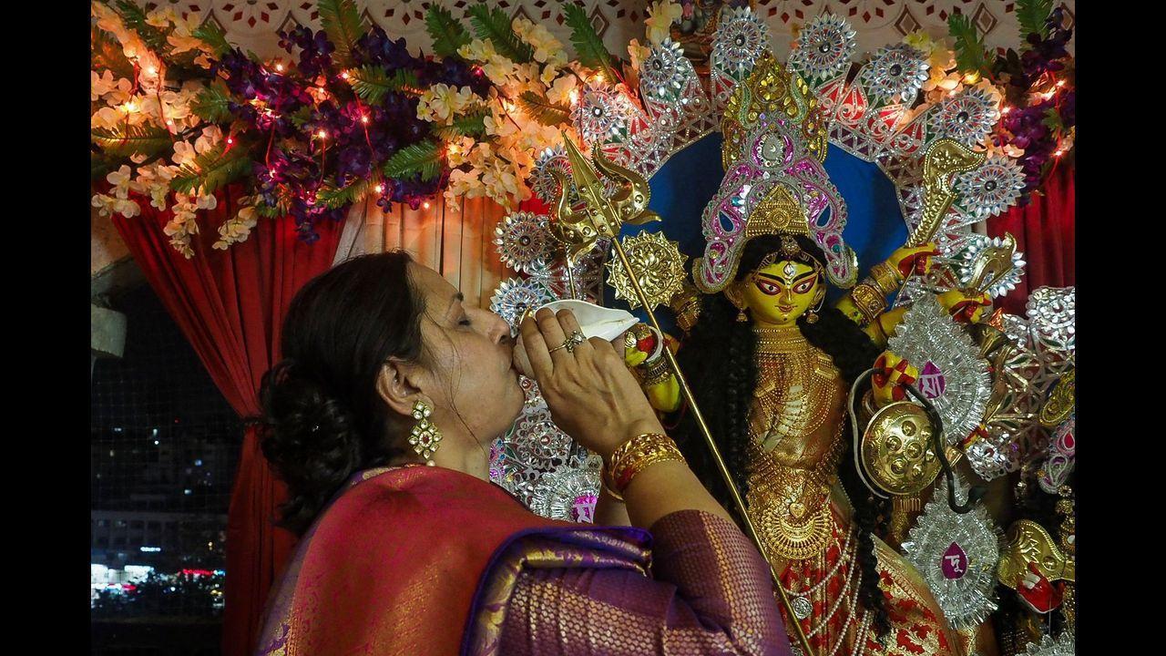 A devotee performs a ritual in front of the clay idol of Hindu goddess Durga during the ongoing Navratri and Durga Puja festival celebrations in Ahmedabad. Pic/PTI