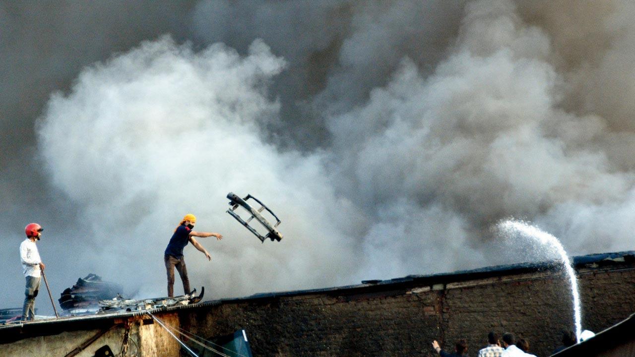 Fire brigade workers try to douse the flames at Dhanraj Jewellers on Waterfield Road, Bandra, in July this year. File pic