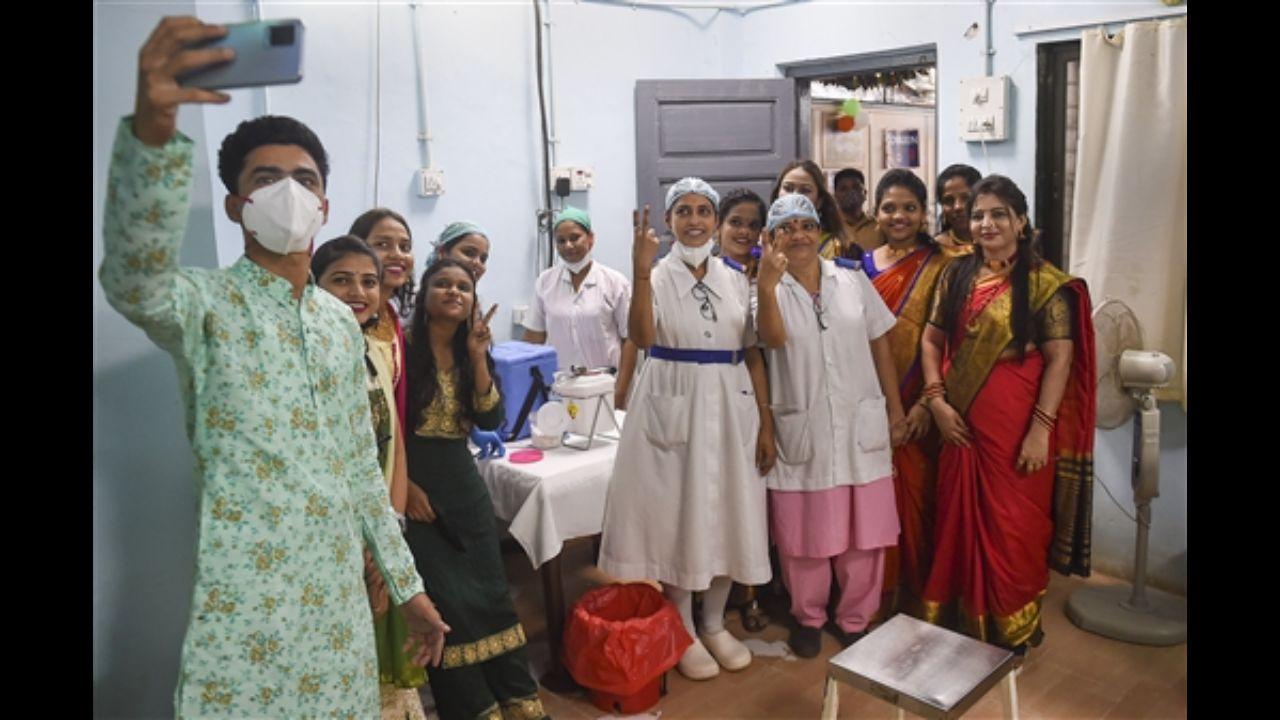 Health workers take a selfie as India crossed the 1 billion Covid-19 vaccine dose milestone at Rajawadi Hospital in Mumbai.