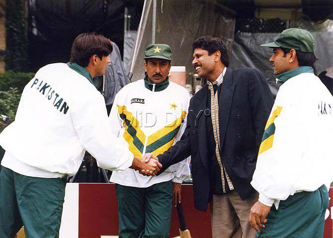 Kapil Dev shakes hands with Shahid Afridi as Saleem Malik looks on