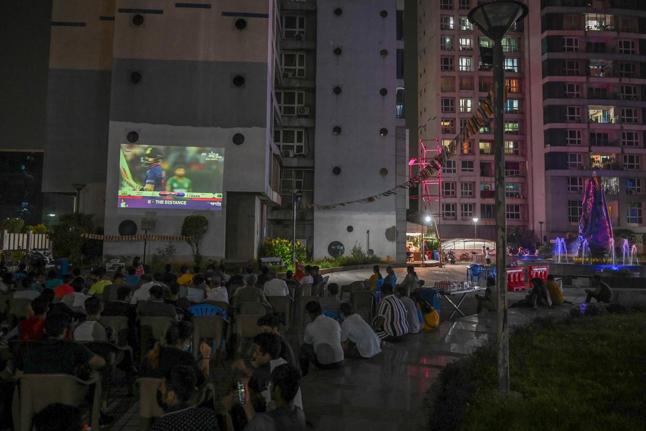 Residents watch the live telecast of the T20 cricket World Cup match between India and Pakistan happening in Dubai on a projector at a residential complex in Chennai 