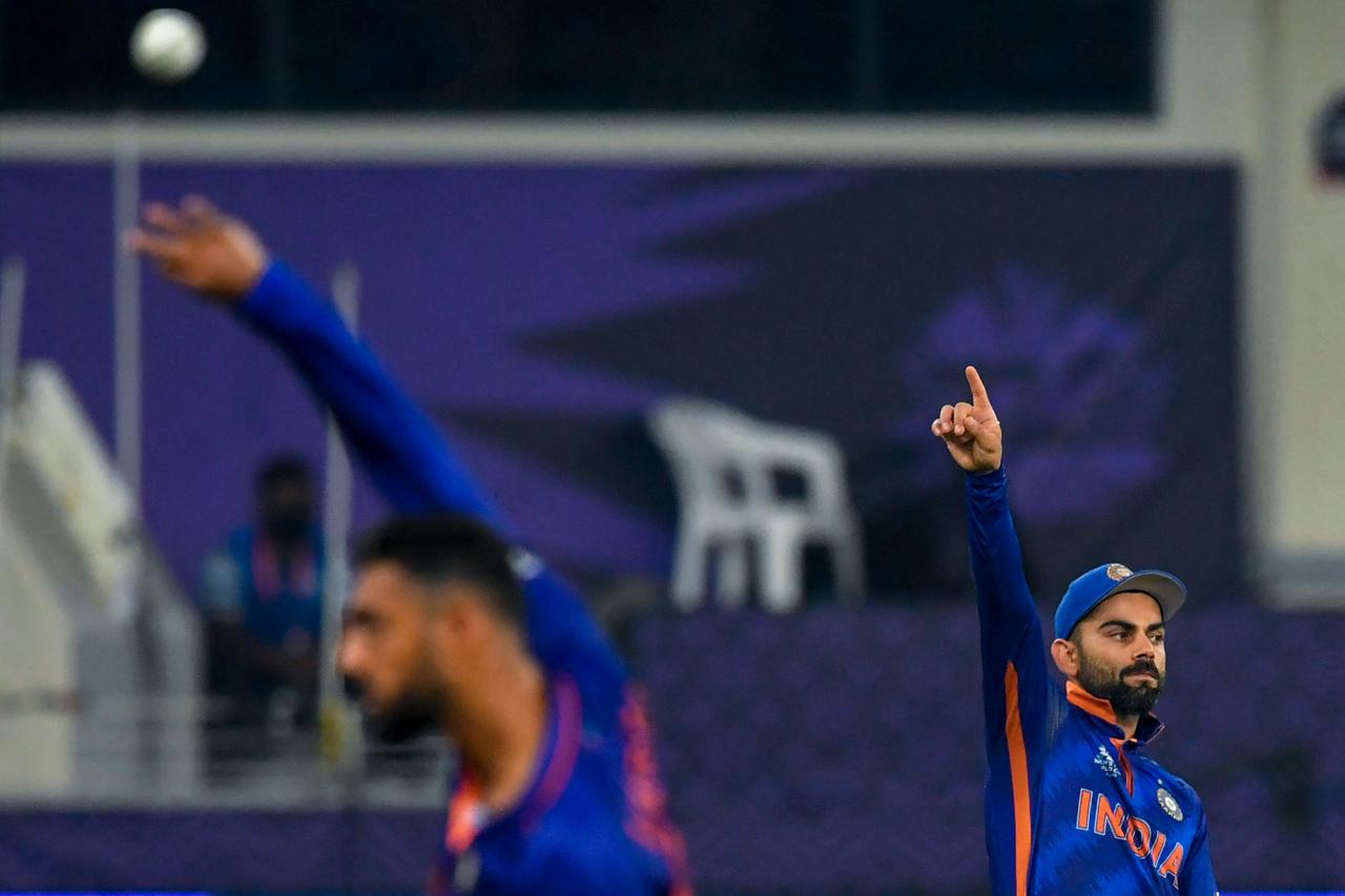 India's captain Virat Kohli (R) sets up the fielding during the ICC men’s Twenty20 World Cup cricket match between India and Pakistan at the Dubai International Cricket Stadium in Dubai