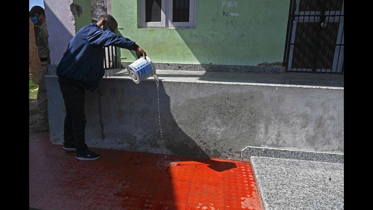 A man cleans blood stains inside a government-run school on the outskirts of Srinagar on October 7, 2021, after suspected anti-India militants shot dead two schoolteachers in Indian-administered Kashmir, police said. Pic/AFP