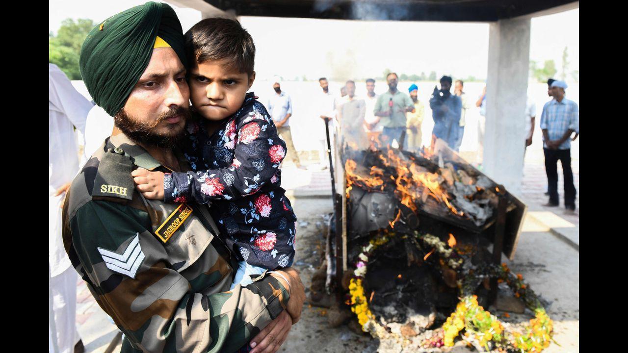 Son (C) and uncle (L) of slain Indian Army soldier Mandeep Singh, who was killed in an encounter that broke out during an anti-insurgency operation in the Poonch sector of Jammu and Kashmir. Pic/AFP