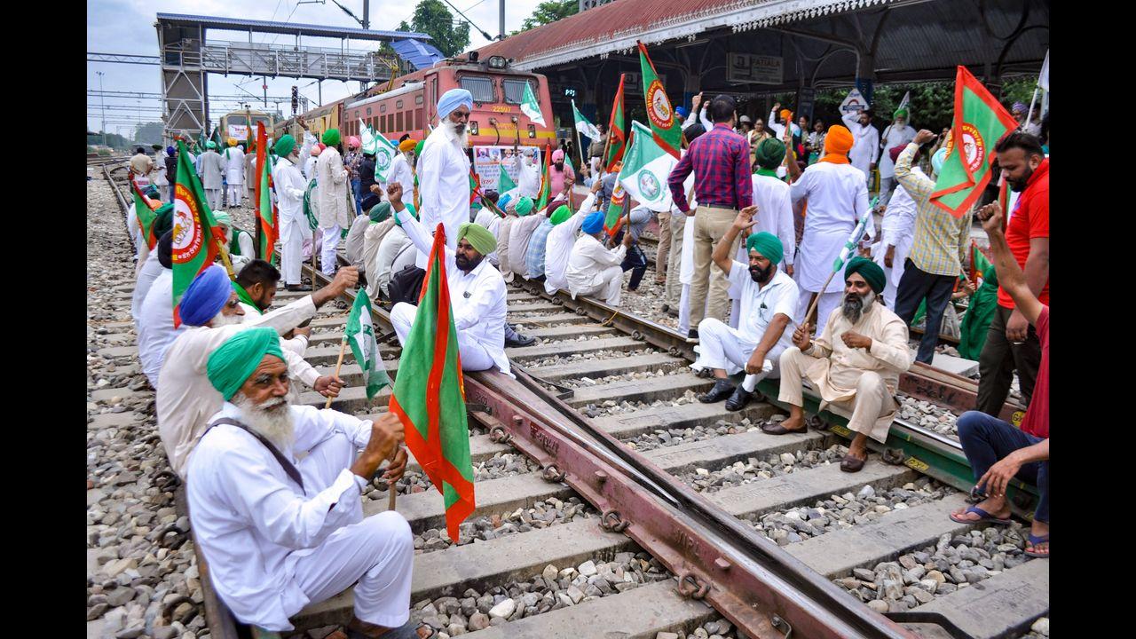 Police personnel stand guard at a railway bridge to prevent farmers from blocking the tracks as part of their 'Rail Roko' protest, in Varanasi. Pic/PTI