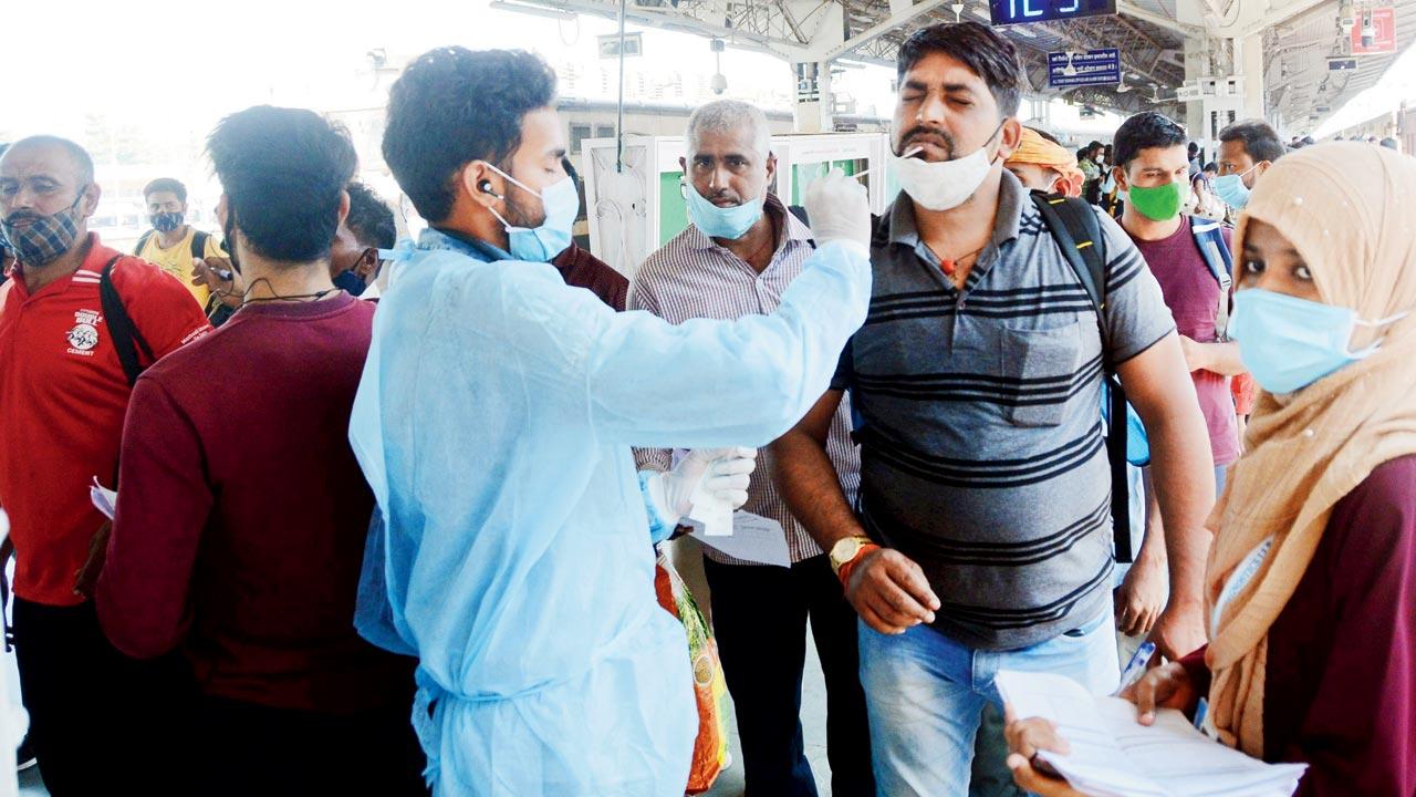A health worker tests a passenger at the Lokmanya Tilak Terminus on Wednesday. Pic/Sayyed Sameer Abedi