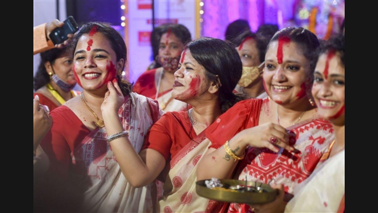 Married women smear vermilion on each other's faces during 'Sindur Khela' on the final day of the Durga Puja festival at Bengal Club in Mumbai. Pic/PTI