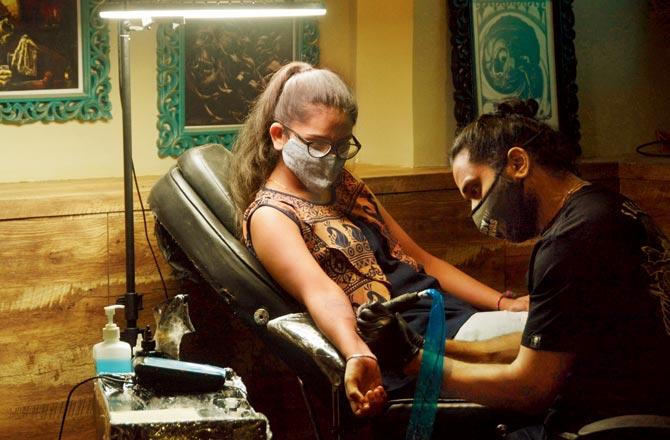Trushna Kachhadiya, a post-graduate student of media and marketing, gets a Coronavirus negative tattoo inked on her arm at artist Vikas Malani-s Bodycanvas Tattoos and Piercings in Malad. Pic/Satej Shinde