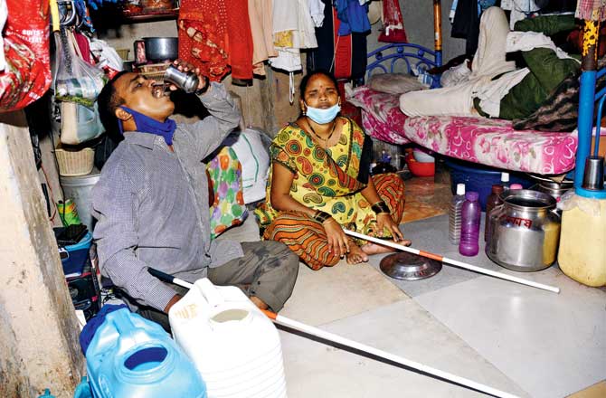 Dhananjay Bhagat and his wife Anita, who are visually impaired, have to walk a distance of 50 metres through the Siddharth Nagar slum to fill water daily. Pics/Sayyed Sameer Abedi