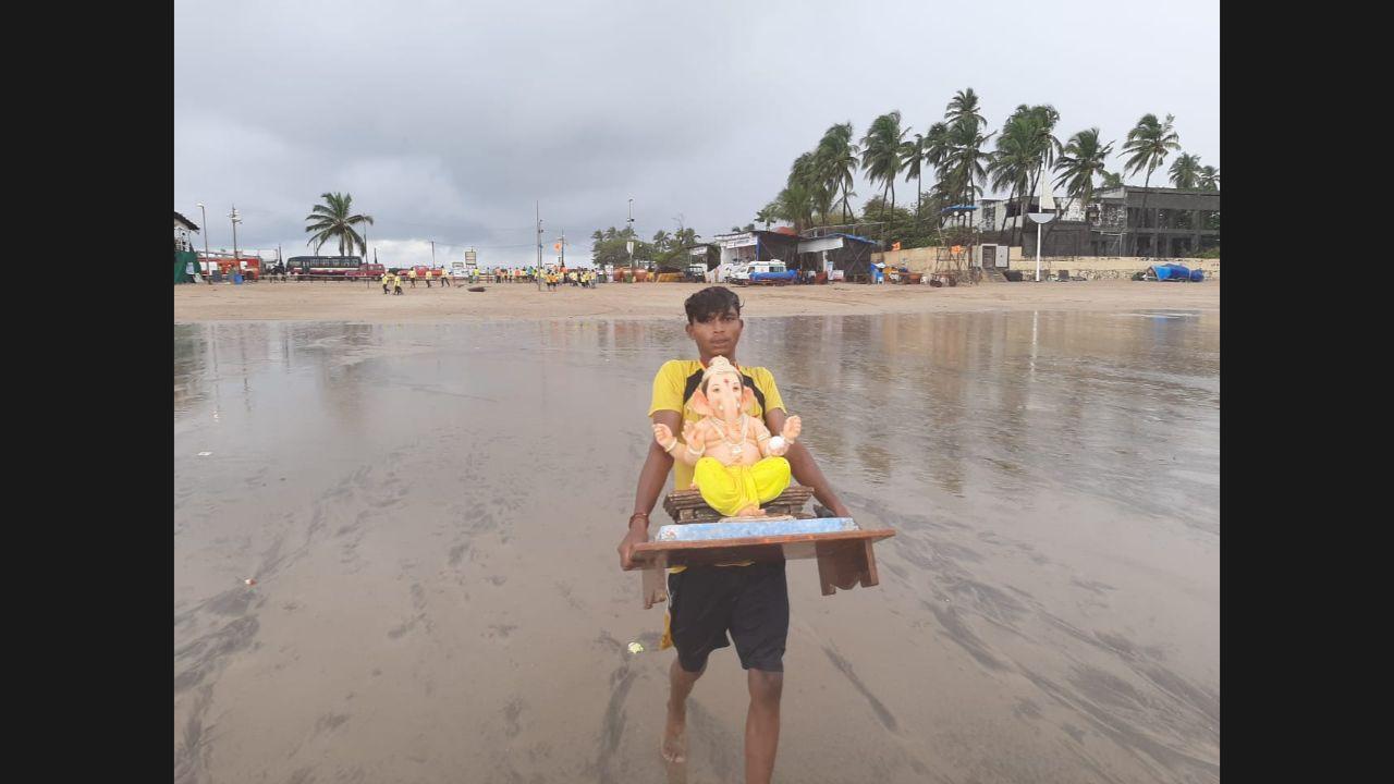 A devotee carrying the idol of Ganpati for immersion at Juhu beach. Pic/Satej Shinde