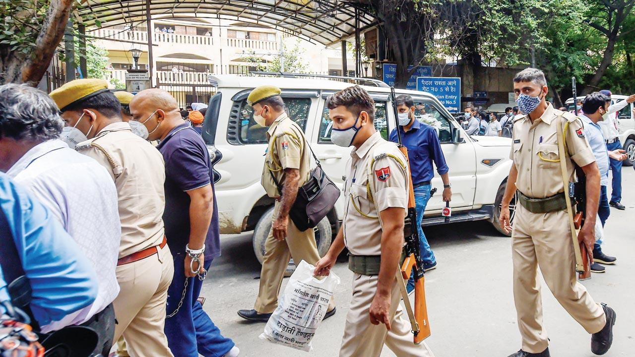  Police personnel and others at the site following a shootout at Rohini Court, where gangster Jitender Gogi was being produced, in New Delhi, on Friday. Pics/PTI