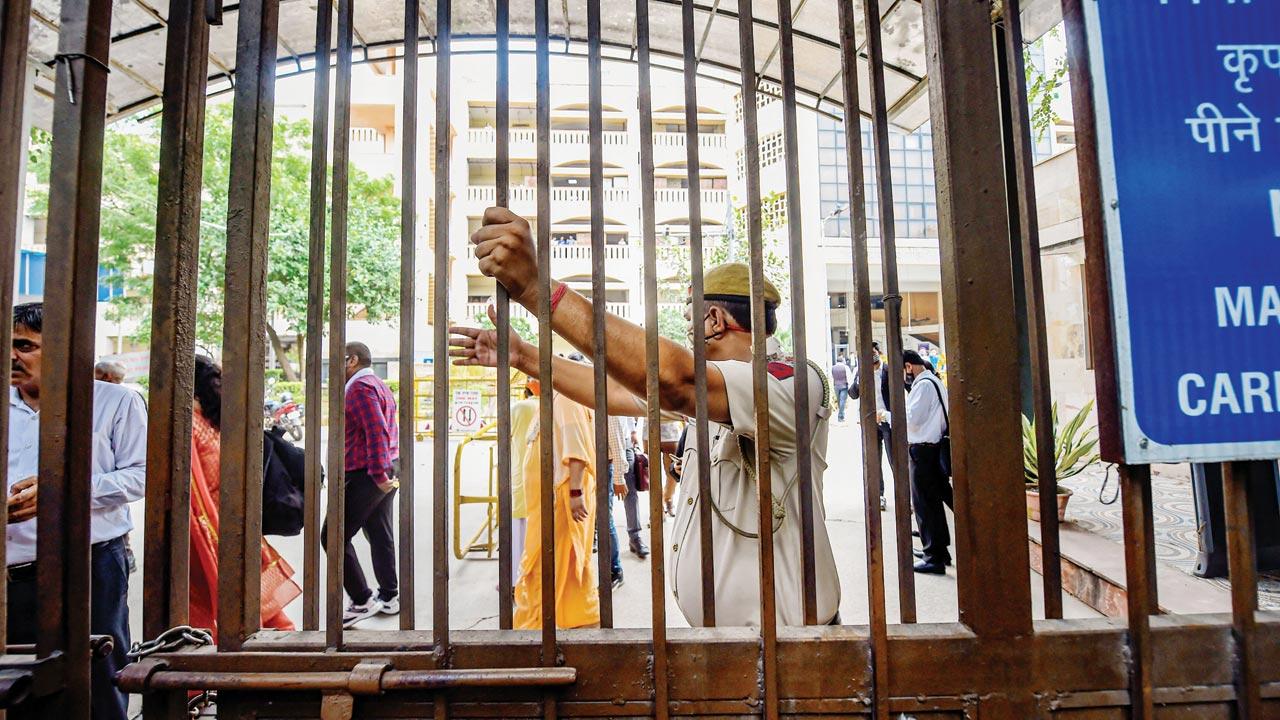  Police personnel and others at the site following a shootout at Rohini Court, where gangster Jitender Gogi was being produced, in New Delhi, on Friday. Pics/PTI