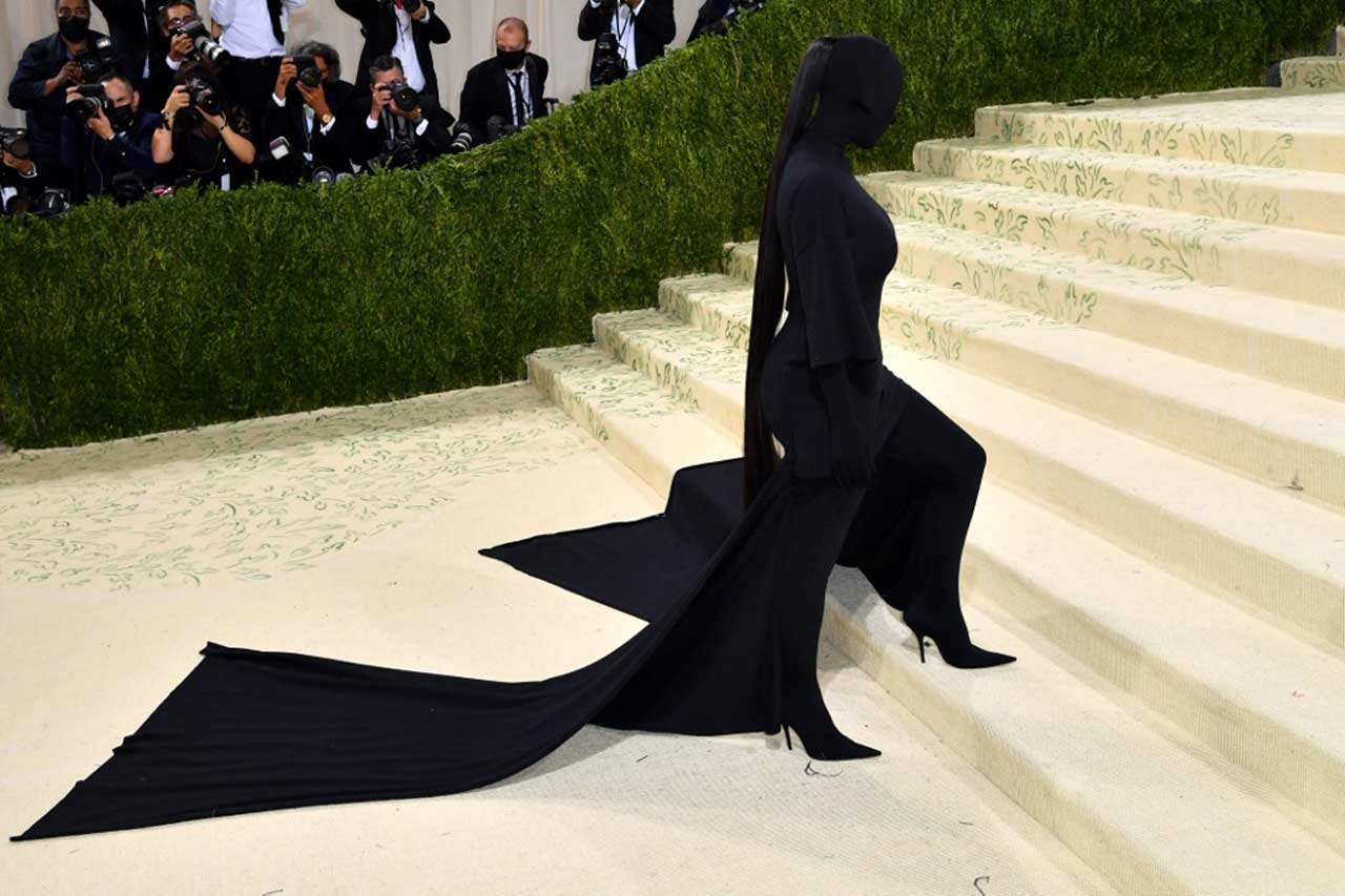 Reality TV star Kim Kardashian hogged the limelight with her undercover look at the Met Gala 2021. She attended the red carpet covering up her face in an all-black head-to-toe Balenciaga ensemble including balaclava. She was basically dressed in a black T-shirt dress over a curve T-shirt with a bodysuit.