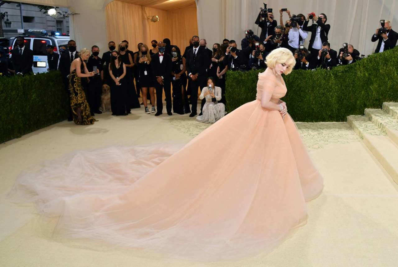 Grammy-award winning artist Billie Eilish chose to keep it all peach for this year's Met Gala as she walked the carpet in a custom tulle corset gown by Oscar de la Renta.