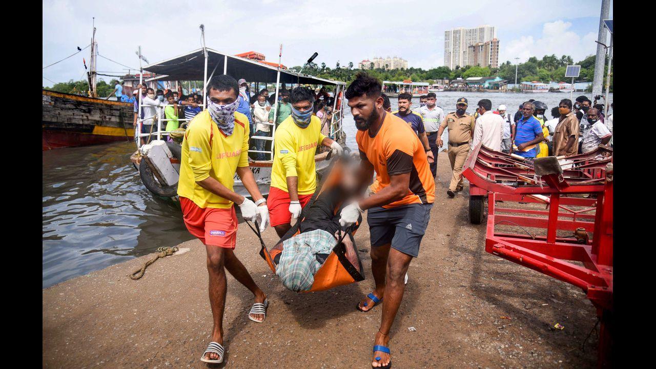People carry the child rescued during a rescue operation after 5 children drowned in the sea during Ganesh Visarjan, at Versova Beach in Mumbai. Pic/PTI