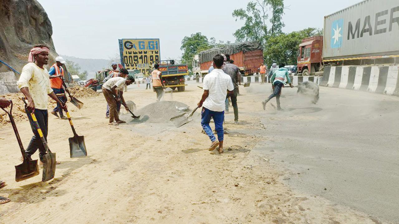 Workers repair the road that got damaged while removing the chemical