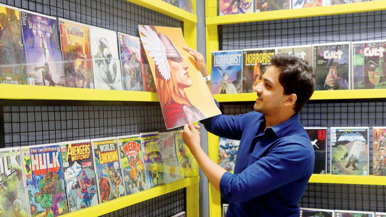 Hamza Sayed holds a Thor poster alongside a Thor #19 comic