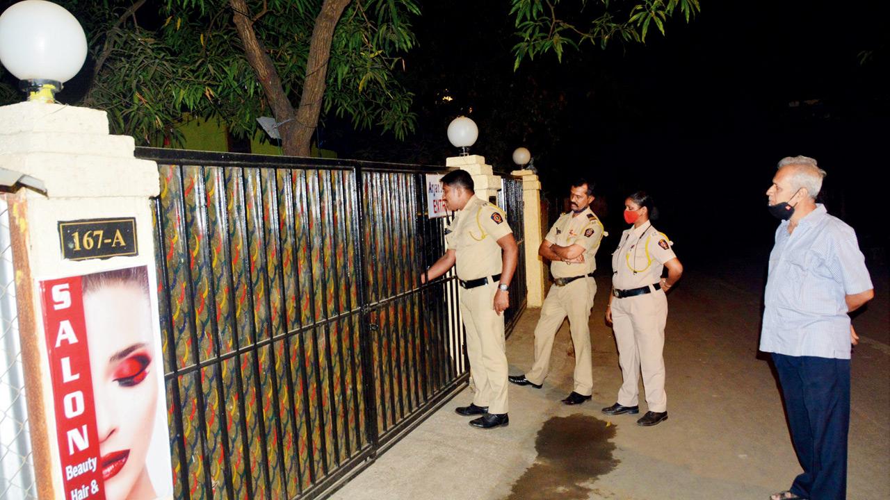 D’Souza with police personnel outside the bungalow in January