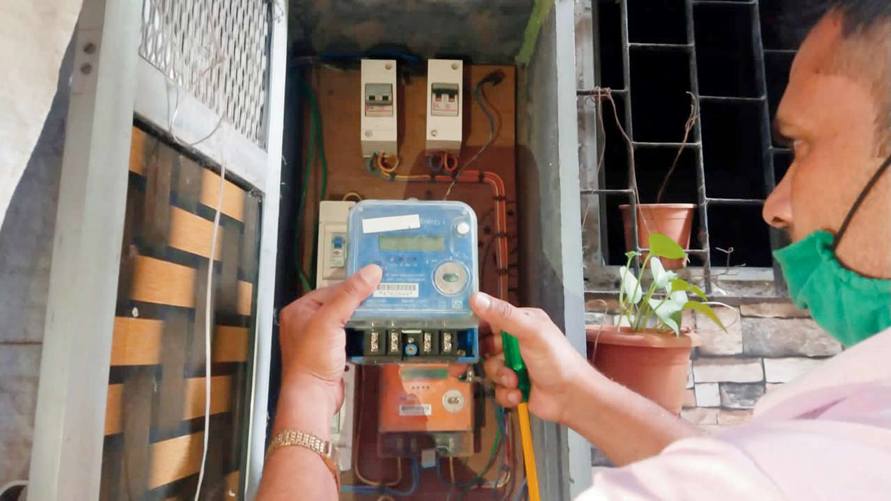 An AEML personnel disconnecting a meter at Siddharth Colony last week