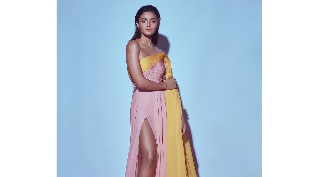 This pink off-shoulder gown, cinched at her waist is definitely a showstopper. The thigh high slit and yellow cape make for an eyecatching combination. Alia's bronzed skin complemented the look perfectly. The actress paired the gown with silver metallic heels. 
 
