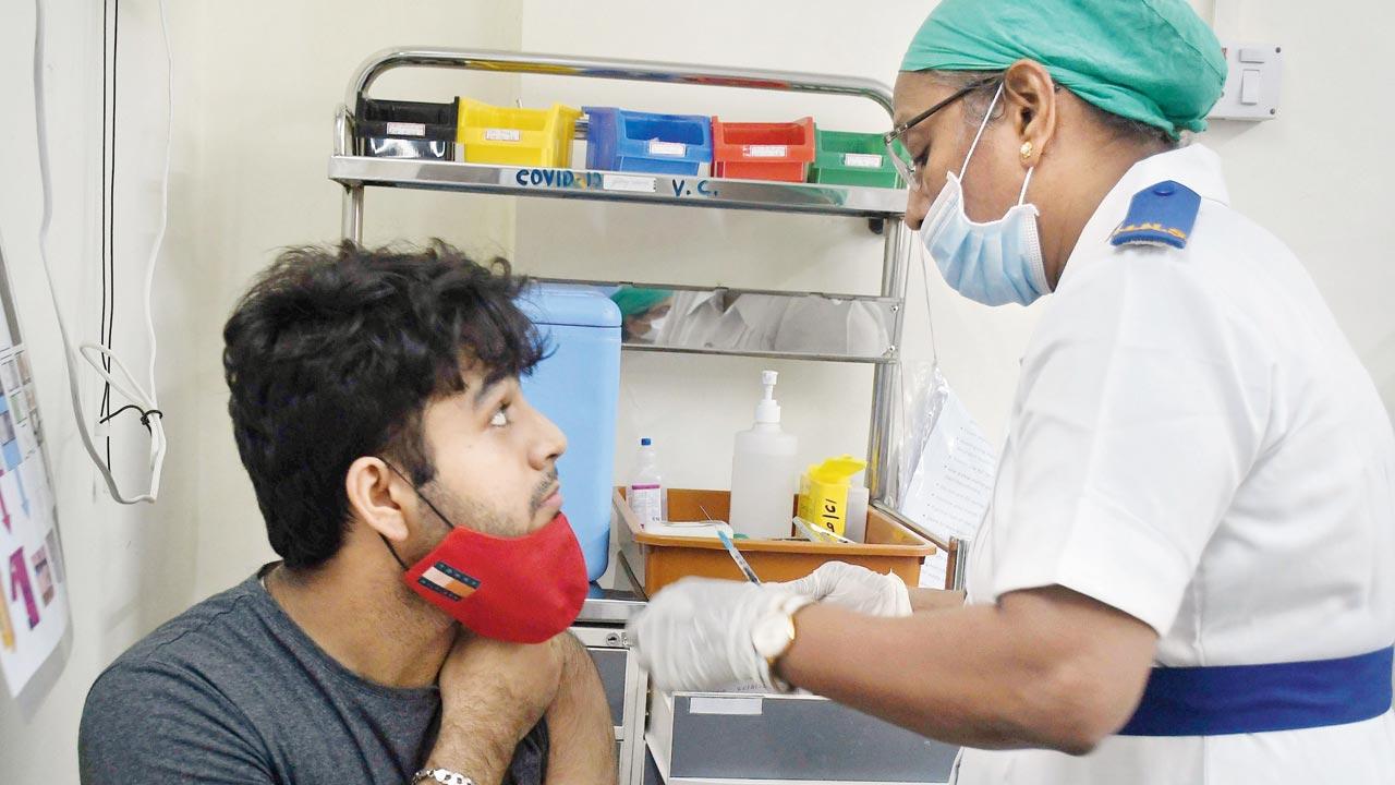 A medic jabs a man against COVID, at Nair hospital, on Tuesday. Pic/Ashish Raje
