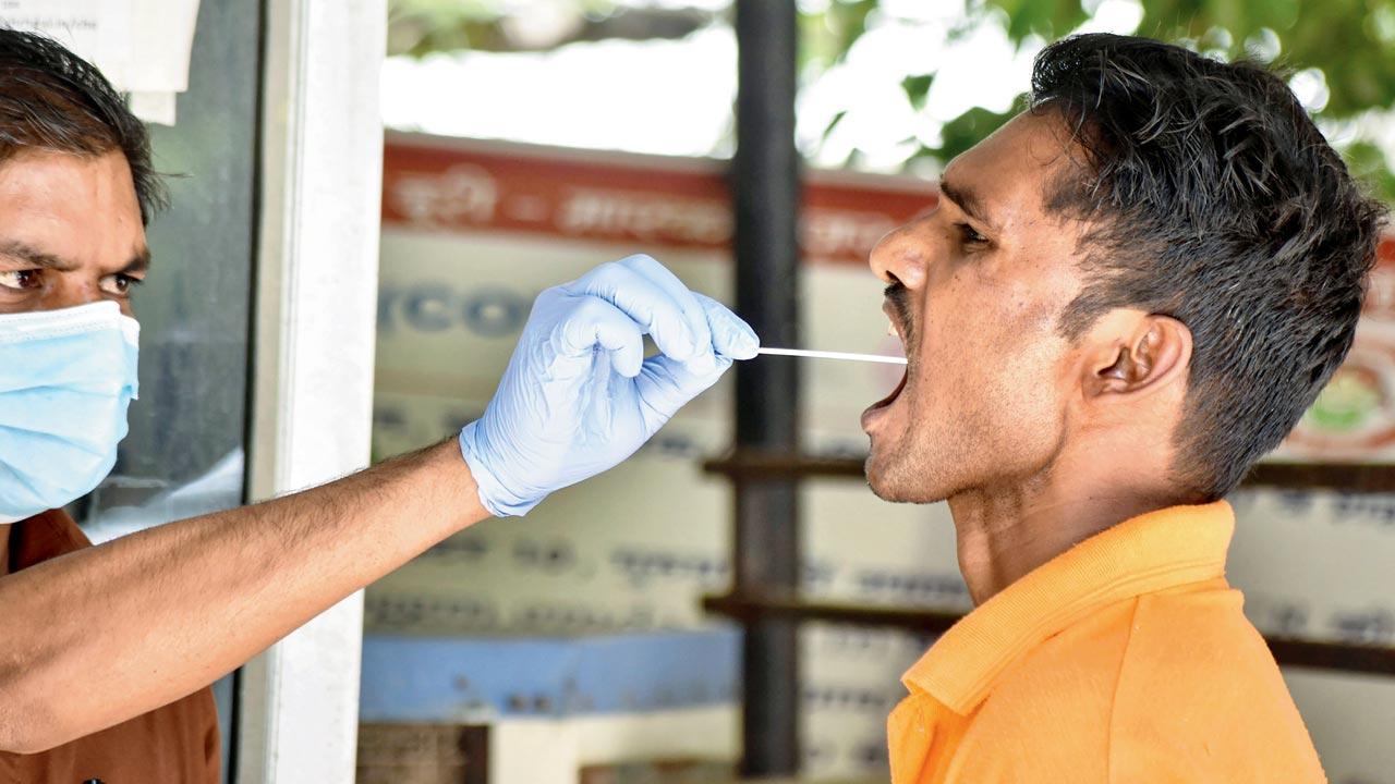 A health worker collects a swab sample in Gurugram on Friday