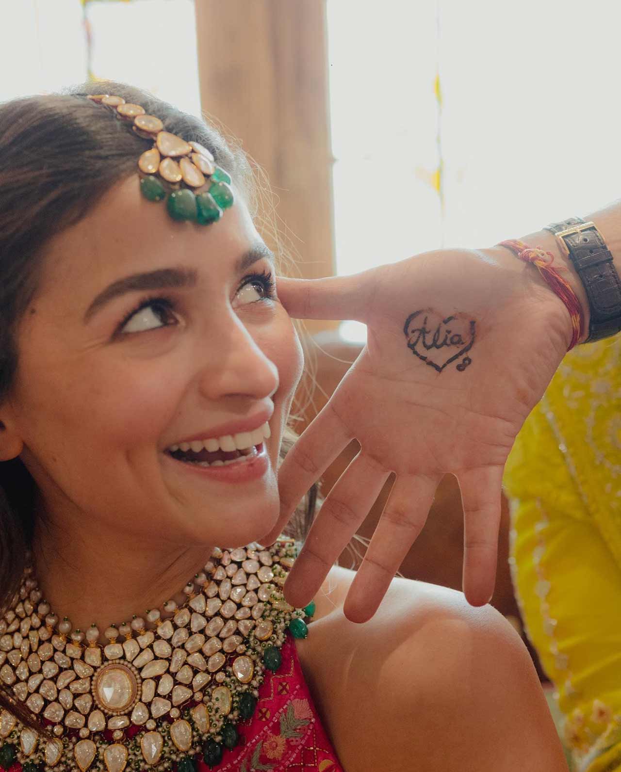 One snap featured Alia Bhatt smiling while looking at Ranbir Kapoor's Mehendi-adorned hand. It had her name written on it inside a heart.