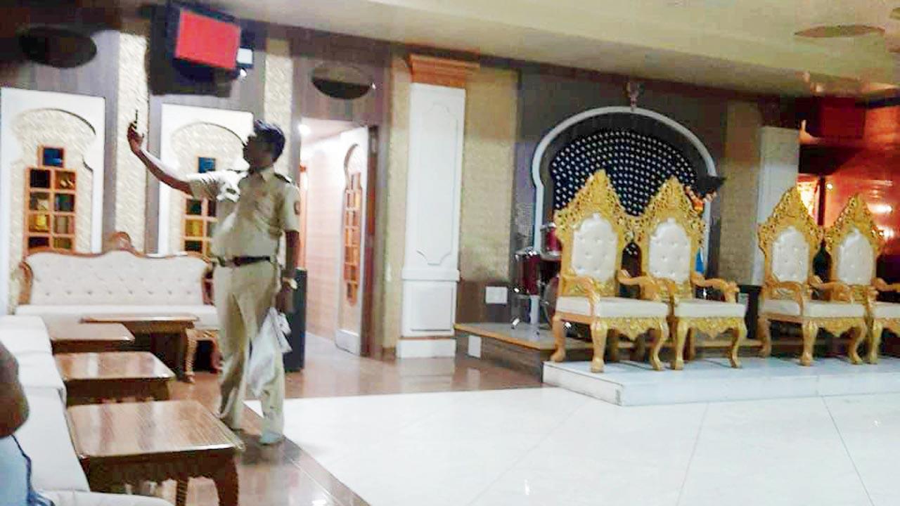 A cop takes a photo of the performers at a dance bar in Chakala, Andheri around 11.34 pm on March 29