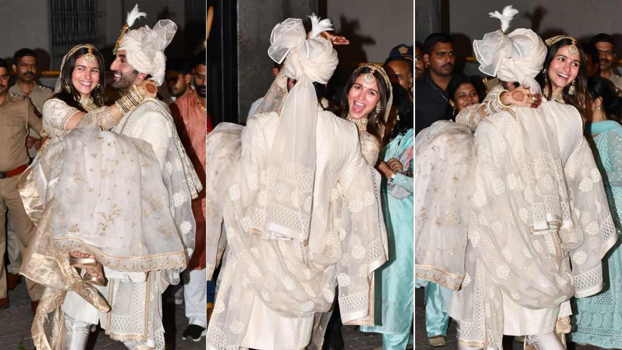Ranbir Kapoor lifts Alia Bhatt in his arms as the newly married couple arrives to pose for the paparazzi