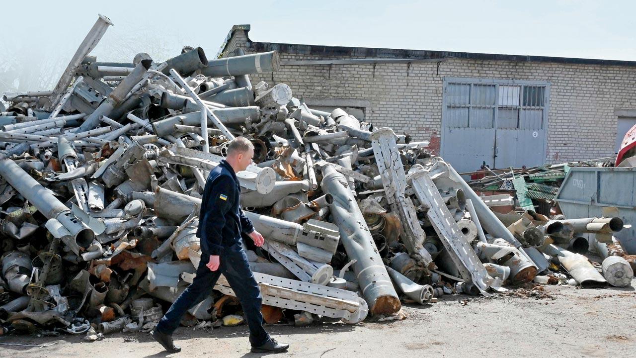 A member of the State Emergency Service of Ukraine walks past a pile of missile remains collected in Kharkiv on Monday. Pics/AFP