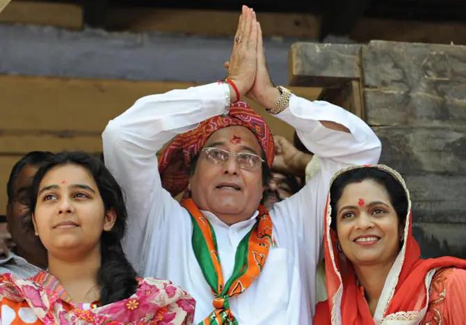 Bharatiya Janata Party (BJP) candidate from Gurdaspur and Indian film actor Vinod Khanna (C), along with his wife Kavita (R)daughter Shraddha (L), gestures to his supporters after filing his election nomination papers in Gurdaspur on April 24, 2009