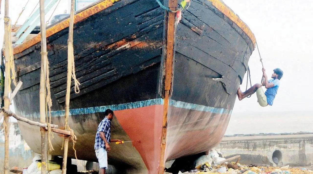 Moored up: With fishing boats taking a monsoon break and awaiting Naral Purnima to resume work, a fisherman in Juhu paints the vessel for a fresh look. Pic/Sayyed Sameer Abedi