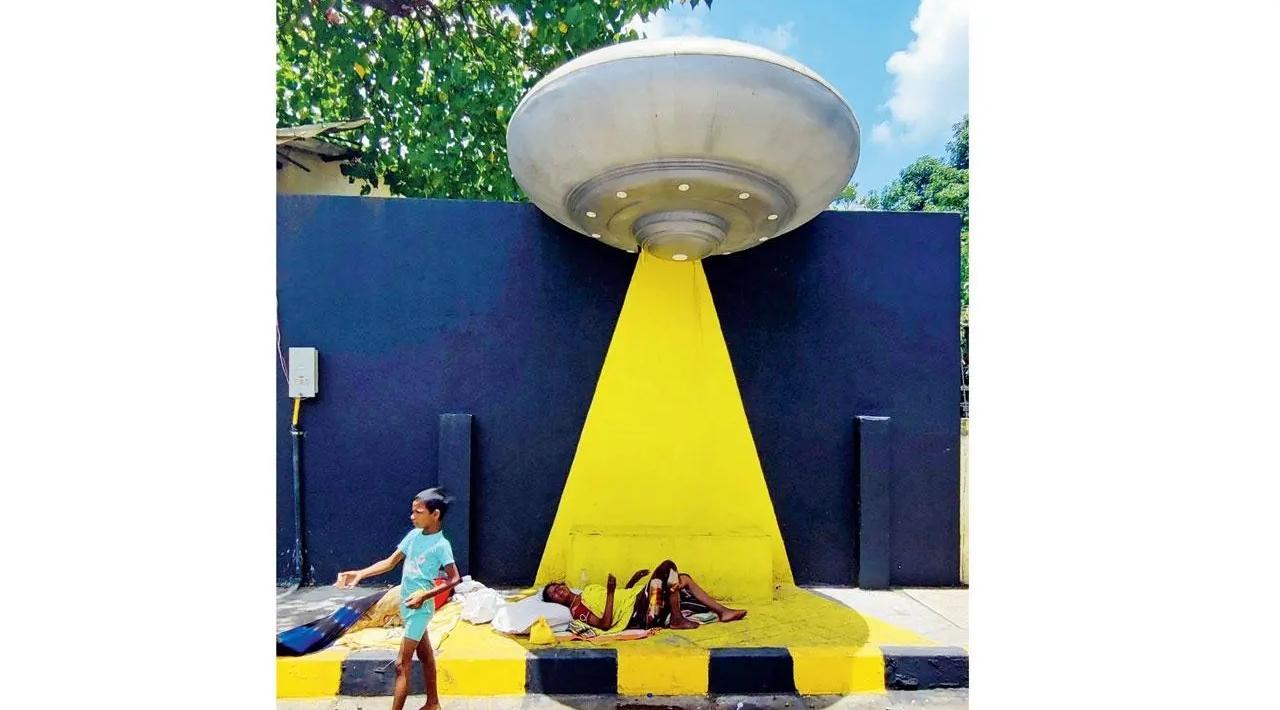 Life under the spotlight: A street-dweller rests beneath a spaceship-inspired art installation at Kalpana Chawla Chowk in Kandivali. Pic/Nimesh Dave