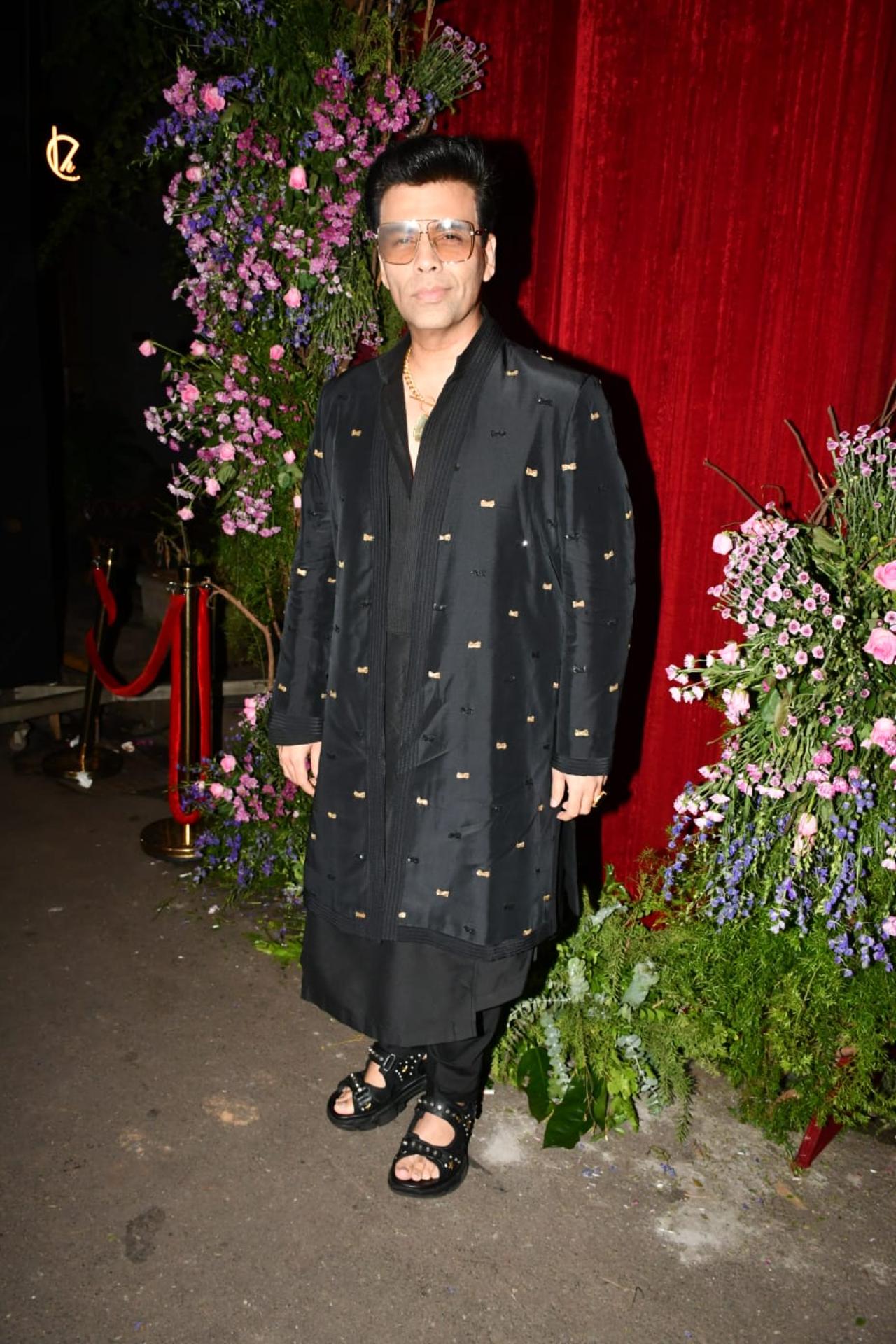 Karan Johar strikes a pose for the paparazzi at the venue in an all-black outfit 