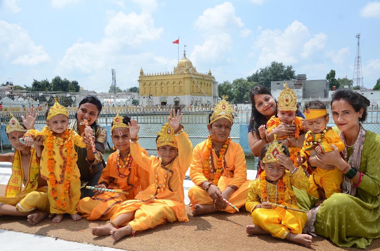Children dressed as Lord Krishna pose for photos on the occasion of 'Janmashtami' at Durgiana Temple in Amritsar. Pic/PTI