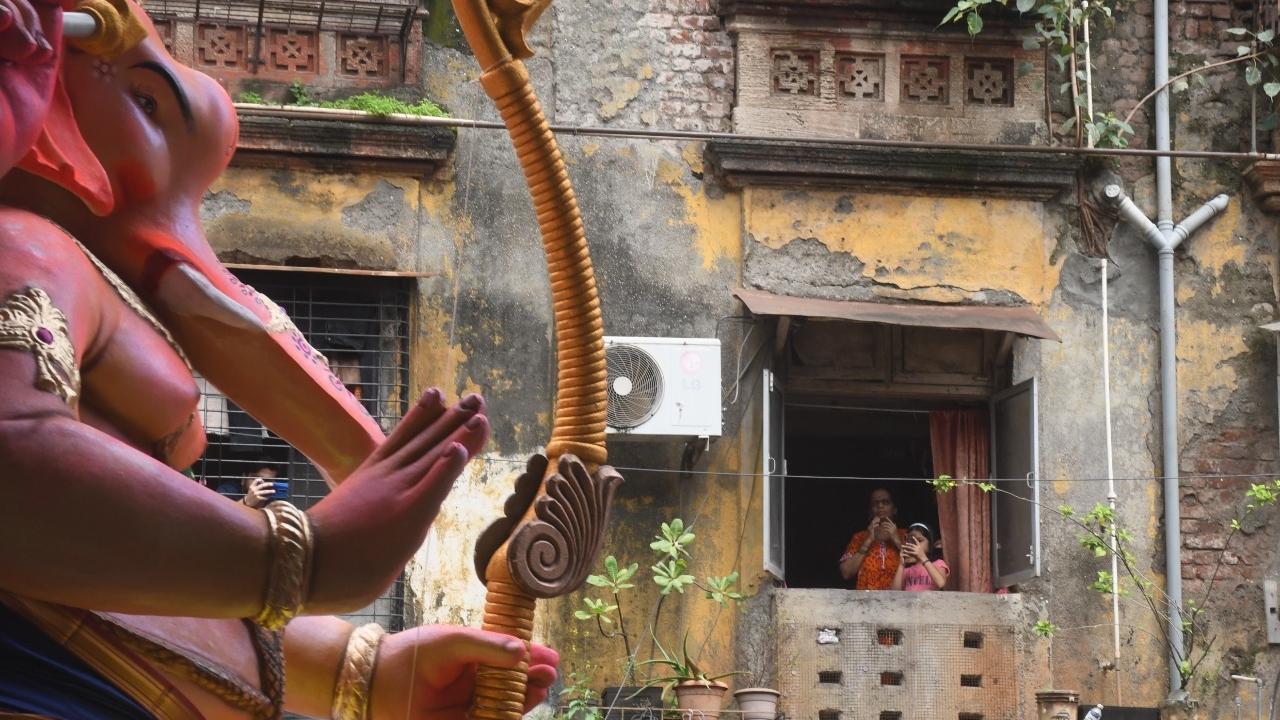 While a resident prays to Lord Ganesh from her balcony, a kid clicks photos of the idol. Pic/Ashish Raje 