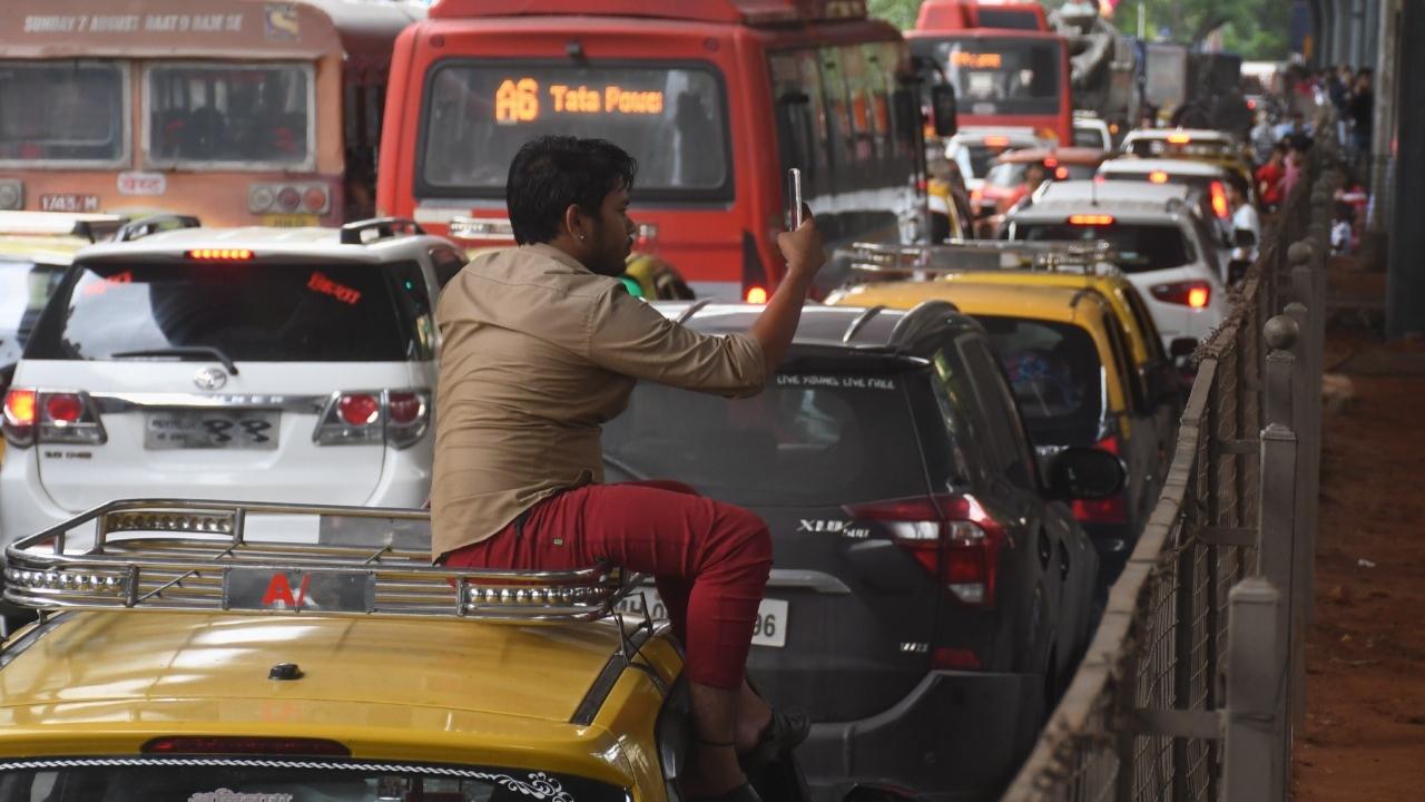 Stuck in a traffic jam, taxi driver clicks photos of Ganpati idols on the Lalbaug road. Pic/Ashish Raje