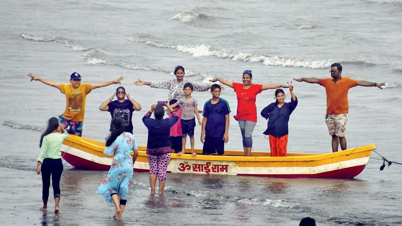 Sea-ze the day: A group of visitors have fun posing on a boat at Girgaum Chowpatty. Pic/Ashish Raje
