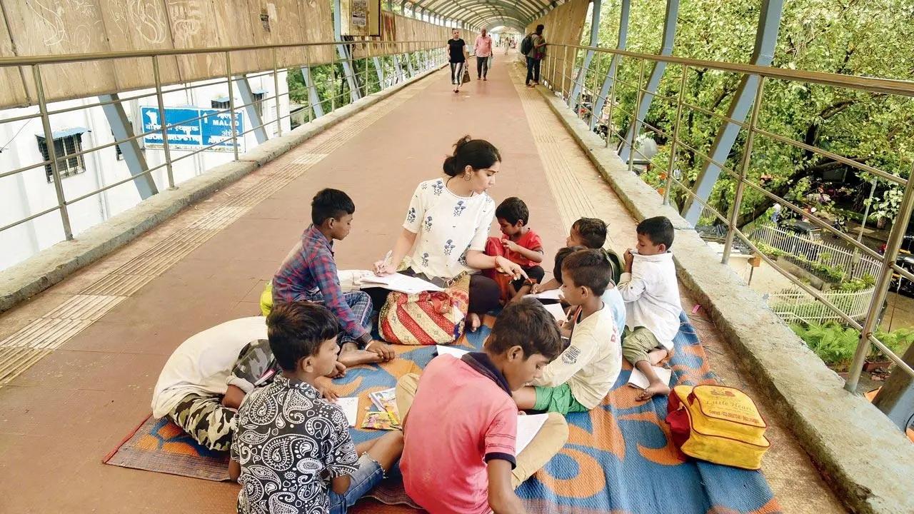 Too cool a school: A teacher from Junoon Foundation conducts a class for street children on the Borivali station skywalk. Pic/Atul Kamble