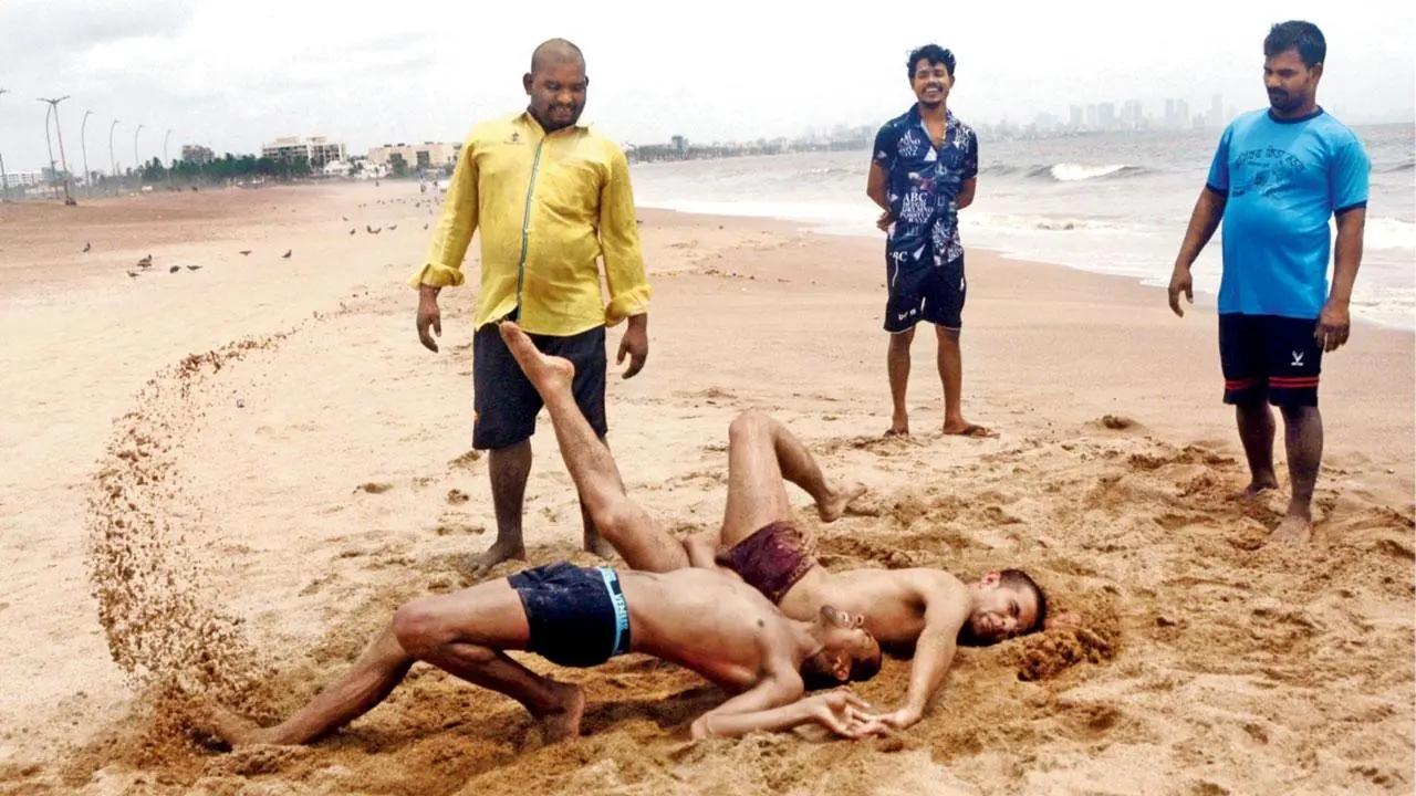 Enter Sandmen: Two wrestlers sling it out at Versova beach under the watchful gaze of their trainer and other bystanders. Pic/Sayyed Sameer Abedi