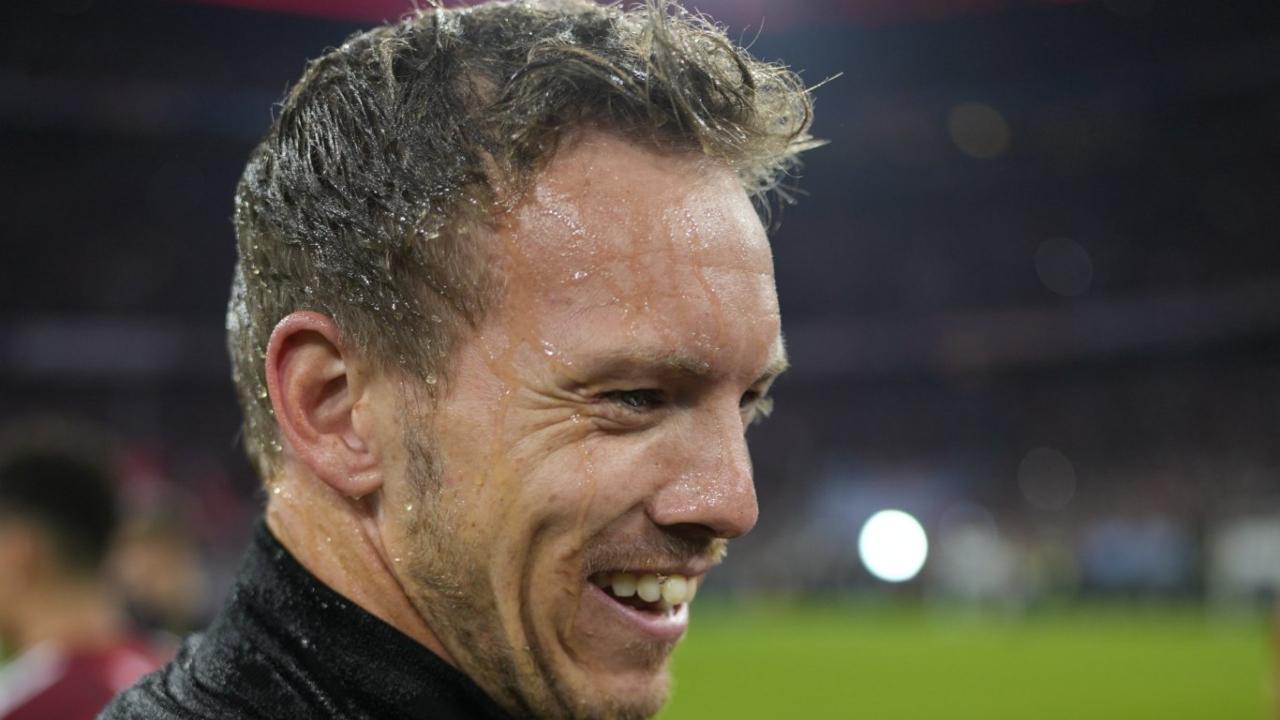Current Manager Julian Nagelsmann smiles as he's drenched all over with the wild celebrations by his players