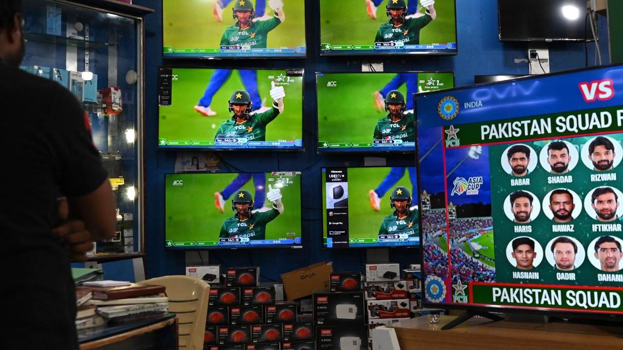 A cricket fan watches the live telecast of the Asia Cup 2022 match between India and Pakistan in Dubai, on television sets displayed for sale at a showroom in Chennai. Photo/AFP